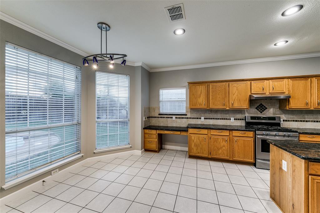 4532 Crown Ridge Drive Plano, TX 75024 - Photo 10 of 25 Open-concept kitchen featuring light wood cabinetry, dark stone countertops, stainless steel appliances, tiled backsplash, and recessed lighting