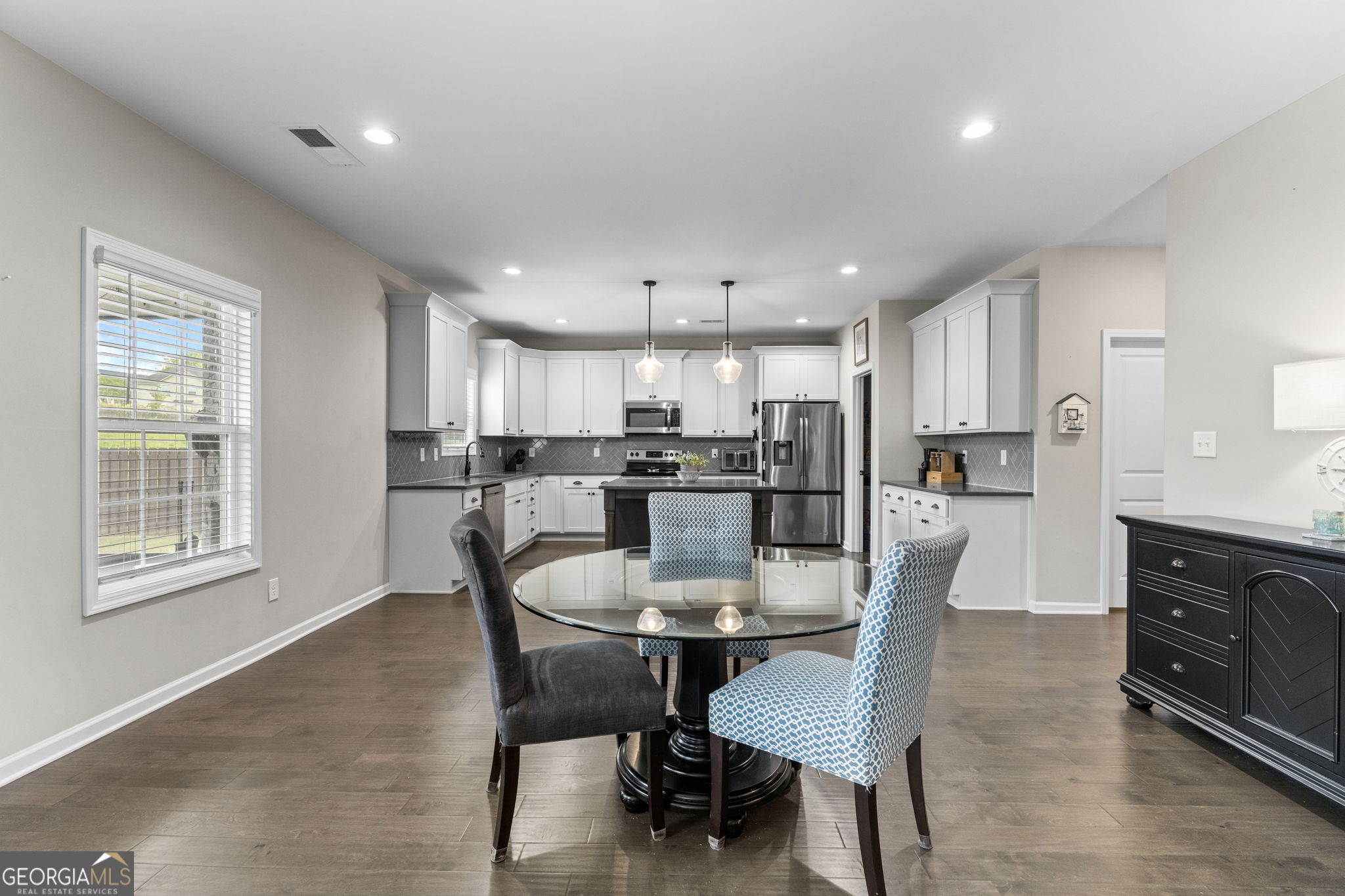 413 Shoshone Circle Kathleen, GA 31047 - Photo 11 of 42 a kitchen with stainless steel appliances granite countertop a dining table chairs refrigerator and microwave
