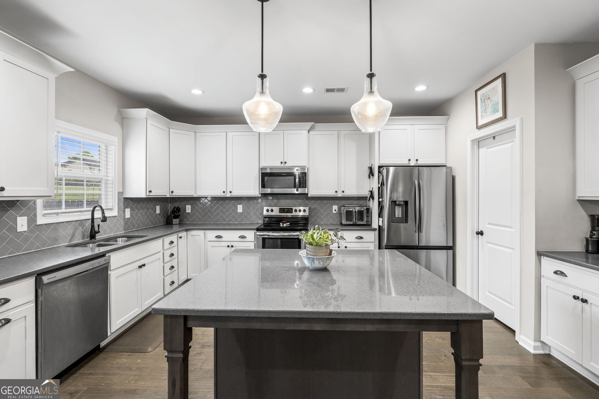 413 Shoshone Circle Kathleen, GA 31047 - Photo 14 of 42 a kitchen with a center island white cabinets and stainless steel appliances