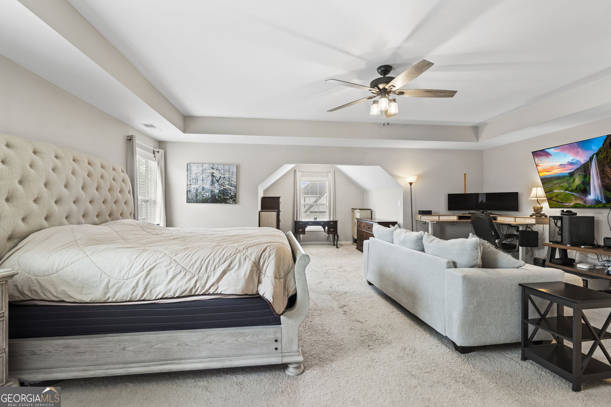 413 Shoshone Circle Kathleen, GA 31047 - Photo 28 of 42 a spacious bedroom with a bed a couch and a chandelier