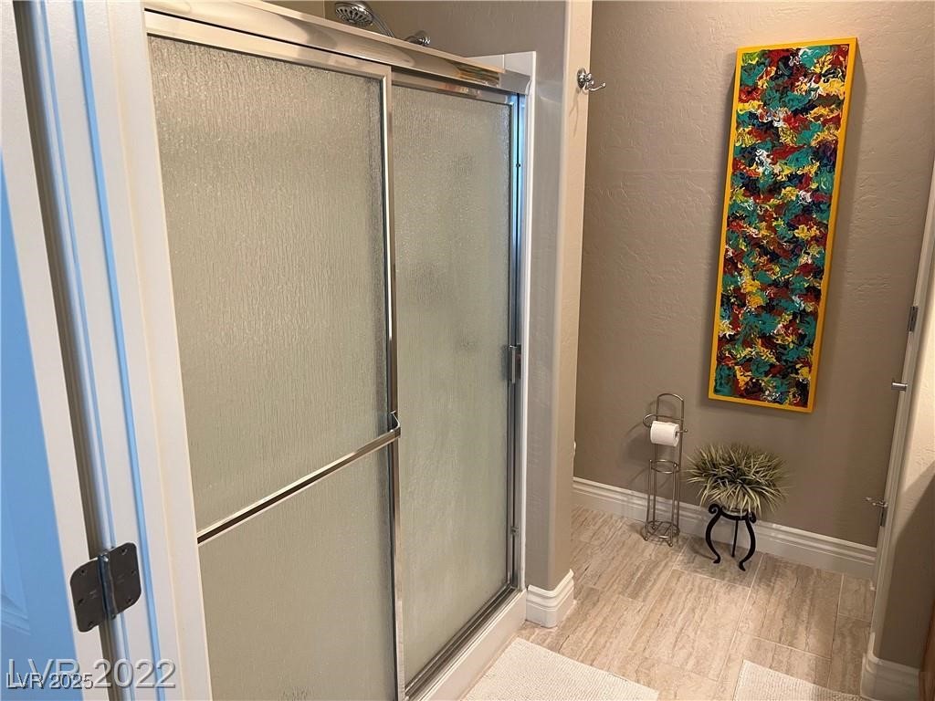 2556 Anani Road Henderson, NV 89044 - Photo 11 of 32 Bathroom with a shower stall, a textured wall, and wood finished floors