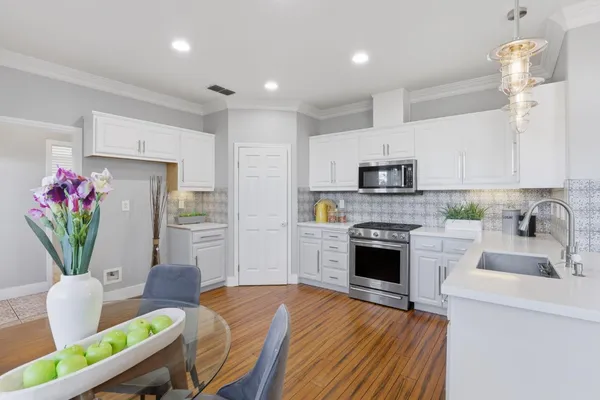 a kitchen with furniture wooden floor and stainless steel appliances