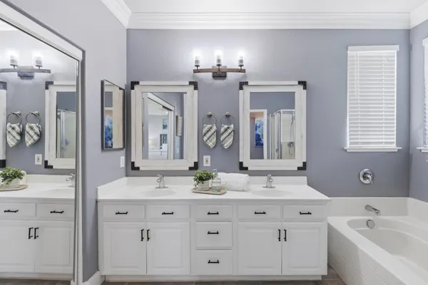 a bathroom with a bathtub a shower a sink and a window