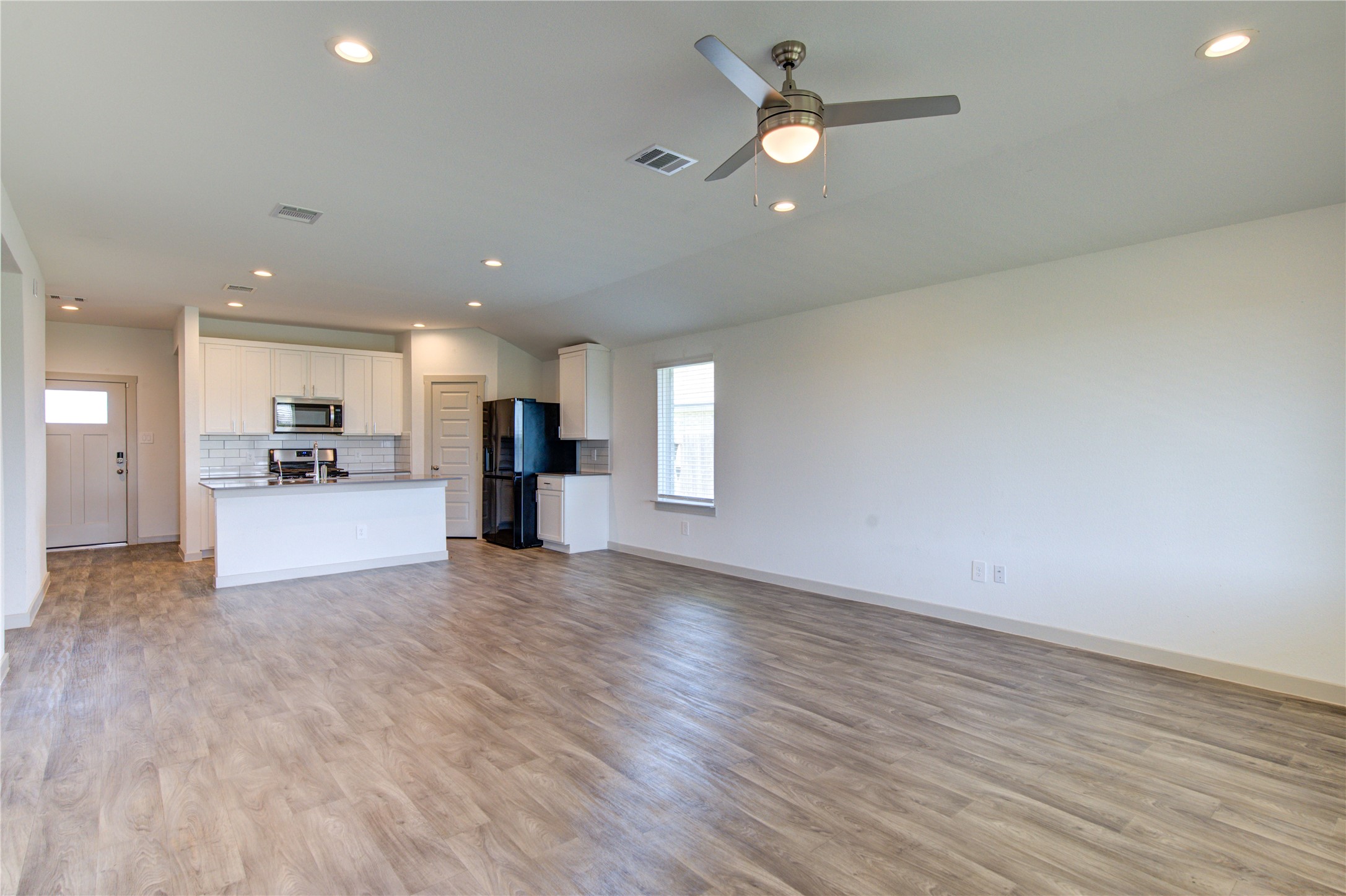 41 Desert Spring Lane Manvel, TX 77578 - Photo 13 of 33 a view of a big room with wooden floor and a kitchen