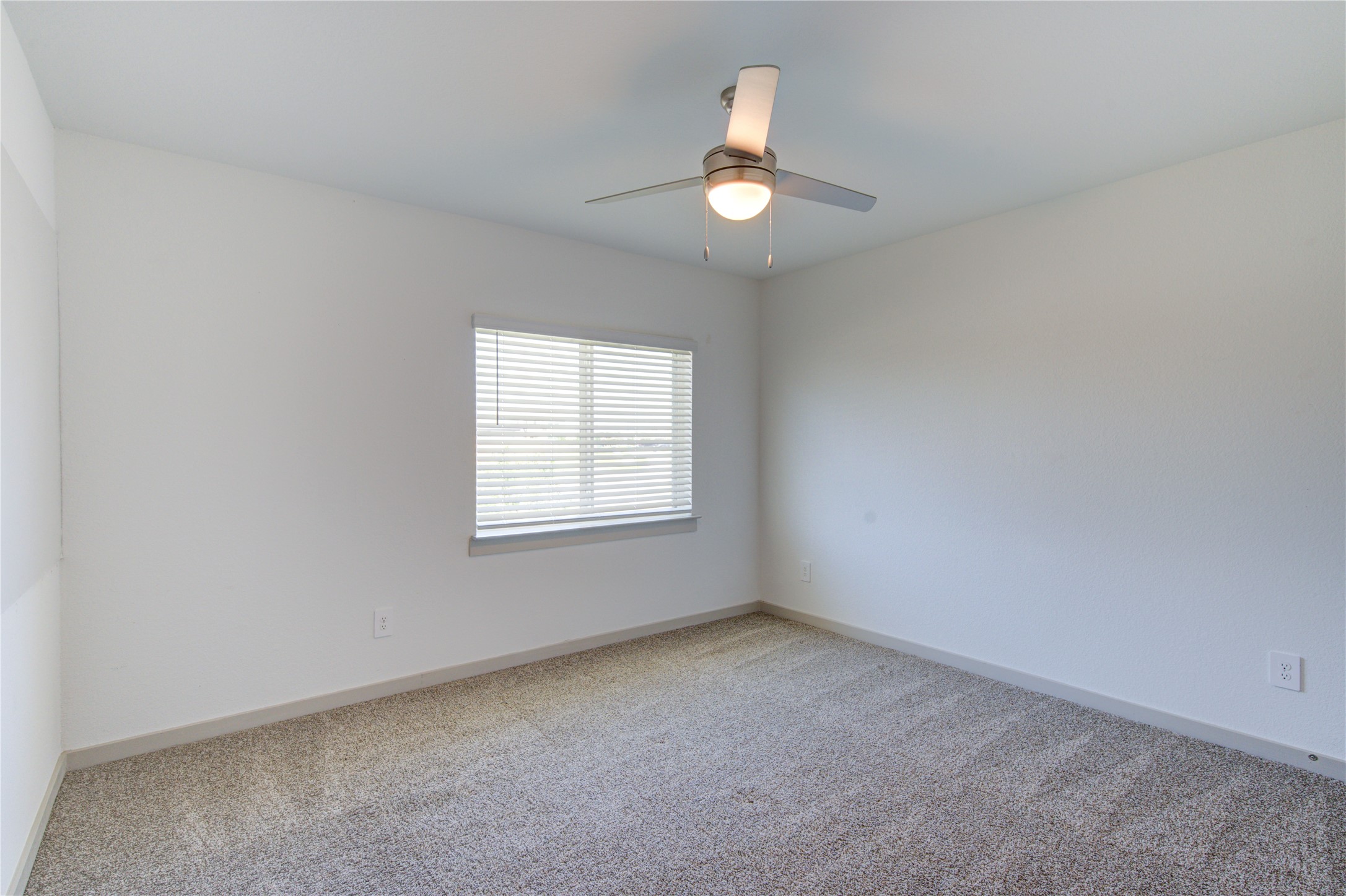 41 Desert Spring Lane Manvel, TX 77578 - Photo 6 of 33 an empty room with a chandelier fan and windows