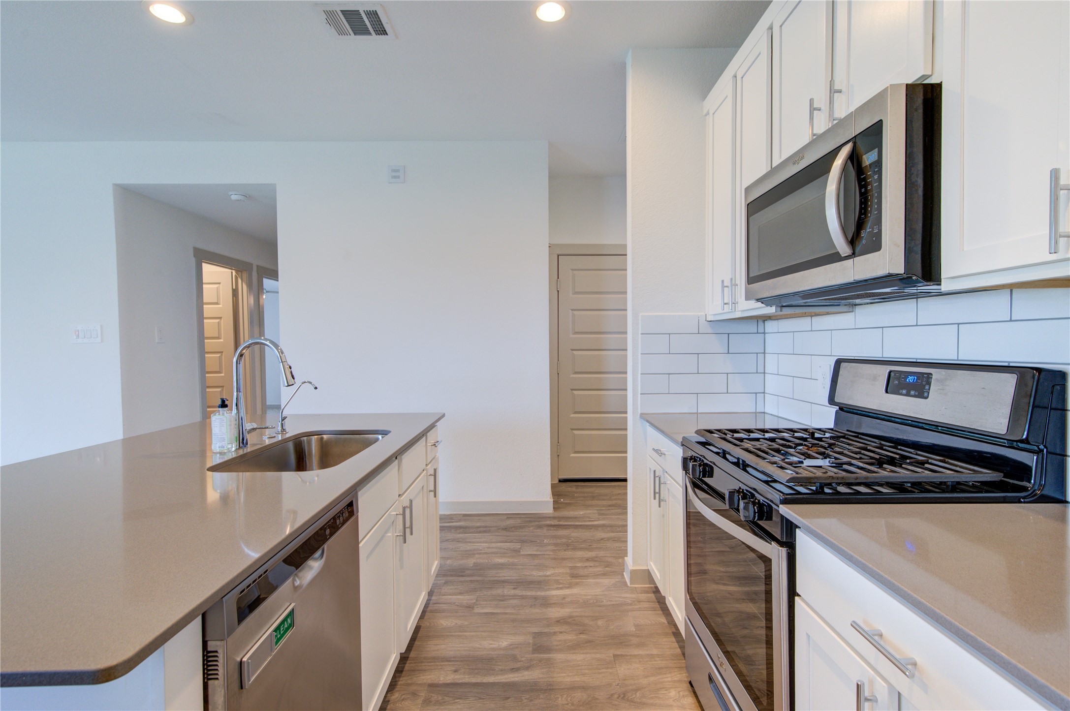 41 Desert Spring Lane Manvel, TX 77578 - Photo 10 of 33 a kitchen with stainless steel appliances a sink a stove and a microwave