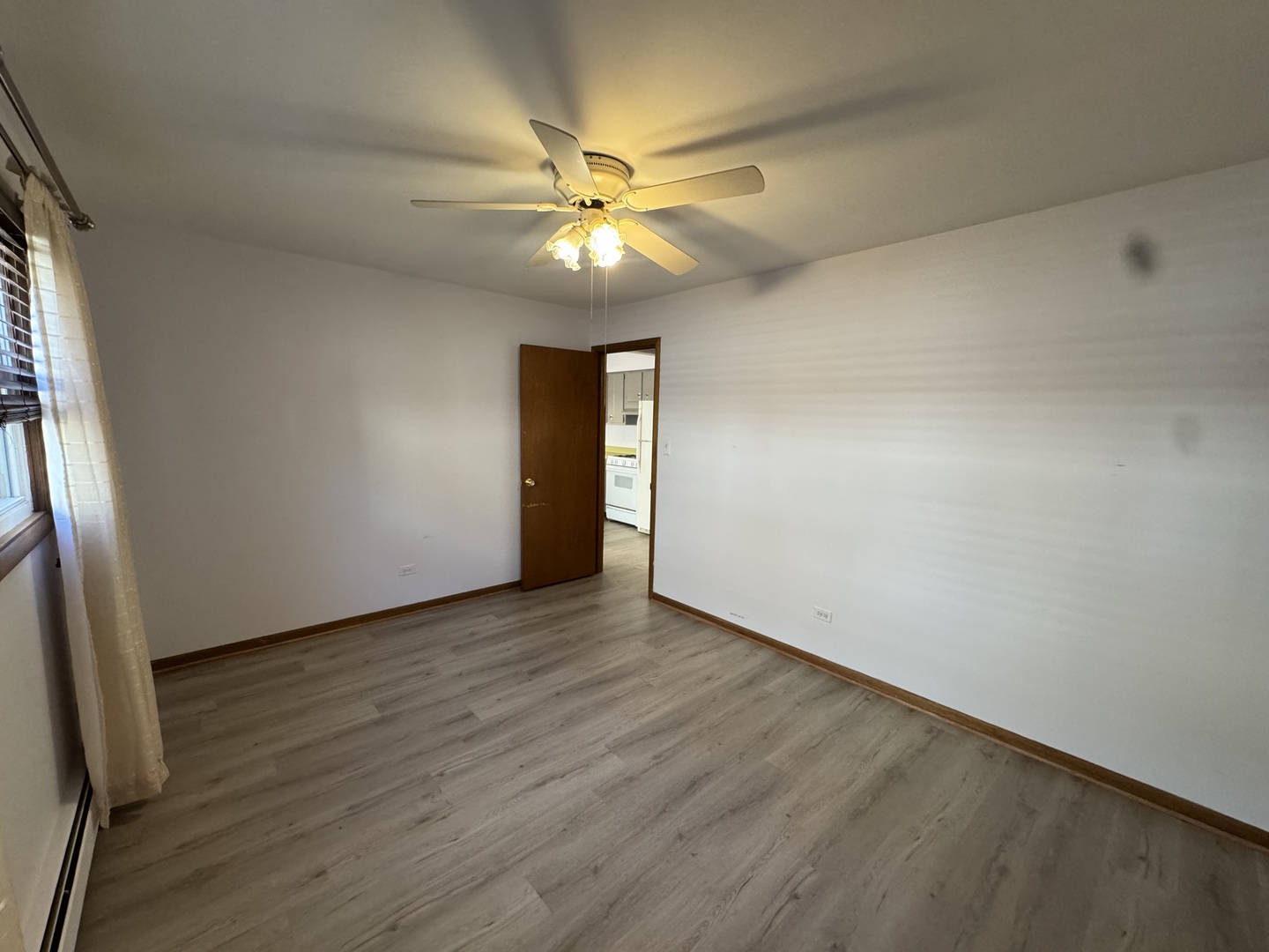 4512 Grove Avenue, Unit 1N Brookfield, IL 60513 - Photo 10 of 10 an empty room with wooden floor fan and windows