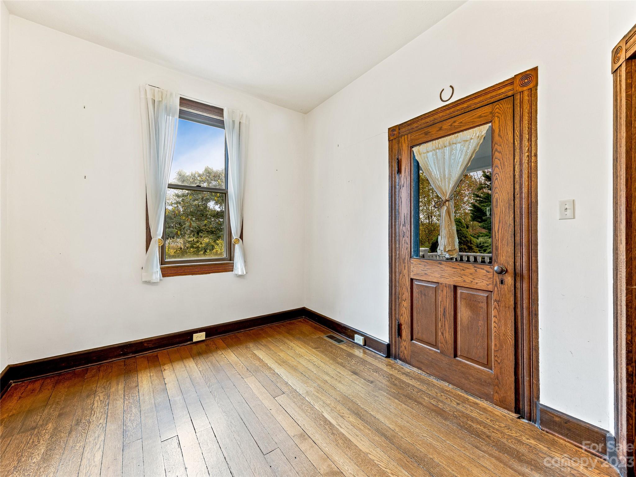 1200 Redmon Road Marshall, NC 28753 - Photo 6 of 37 an empty room with wooden floor and a window