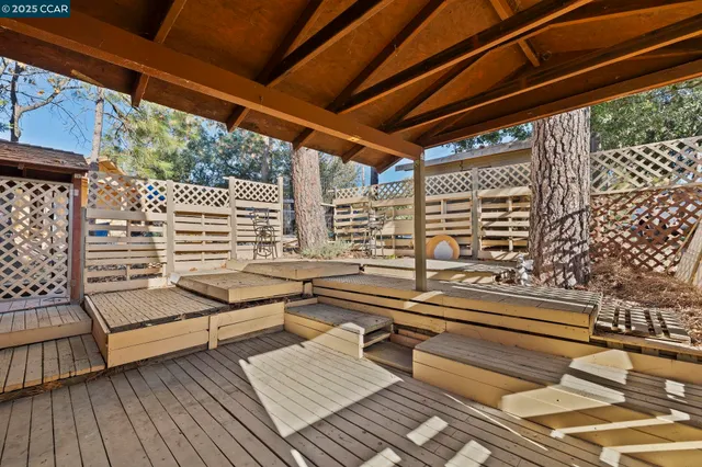 a roof deck with wooden floor and outdoor seating