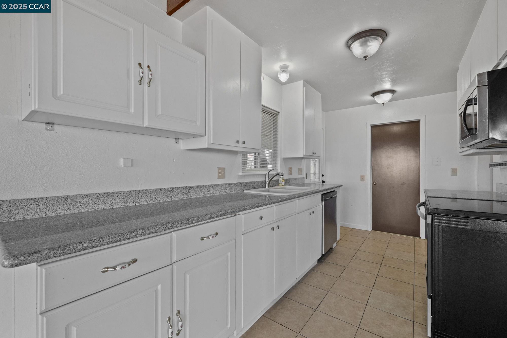 18957 Stag Circle Tuolumne, CA 95379 - Photo 4 of 22 a kitchen with granite countertop white cabinets and stainless steel appliances