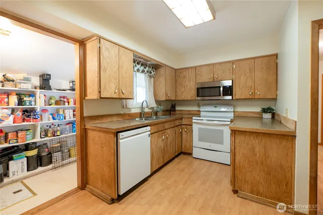 a kitchen with stainless steel appliances granite countertop a stove top oven a sink dishwasher and a microwave oven with cabinets