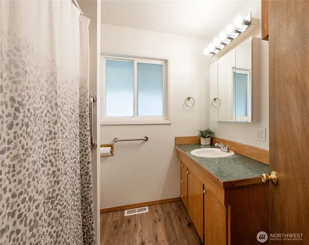 a bathroom with a granite countertop sink and a mirror