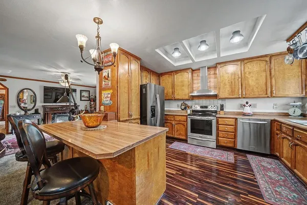 a kitchen with stainless steel appliances granite countertop a stove a sink and a microwave