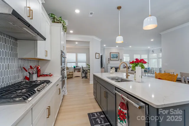 a kitchen with stainless steel appliances granite countertop a stove a sink and a wooden floors