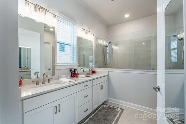 a bathroom with a double vanity sink mirror and shower