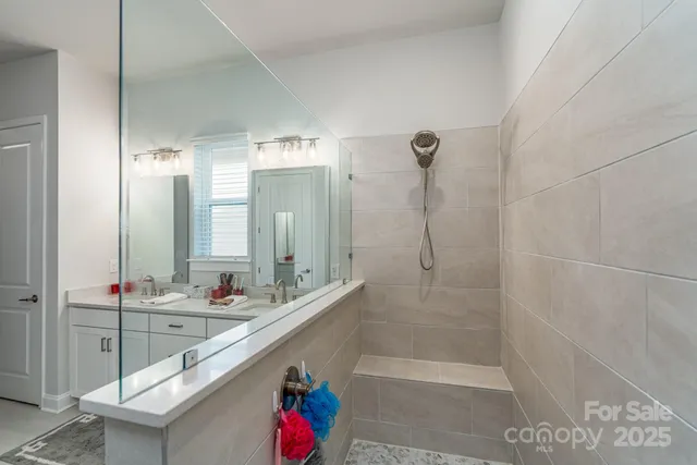 a bathroom with a double vanity sink mirror and shower
