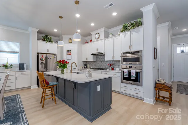 a kitchen with kitchen island granite countertop a sink a counter top space appliances and cabinets
