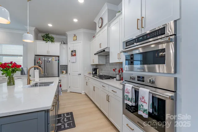 a kitchen with stainless steel appliances kitchen island granite countertop a sink and cabinets