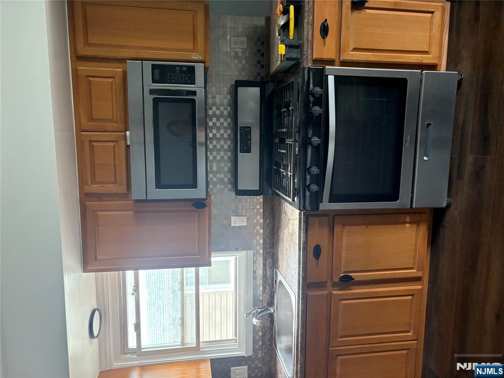 10 Strong Street, Unit 2 Wallington, NJ 07057 - Photo 5 of 12 a kitchen with granite countertop a stove a microwave and wooden cabinets