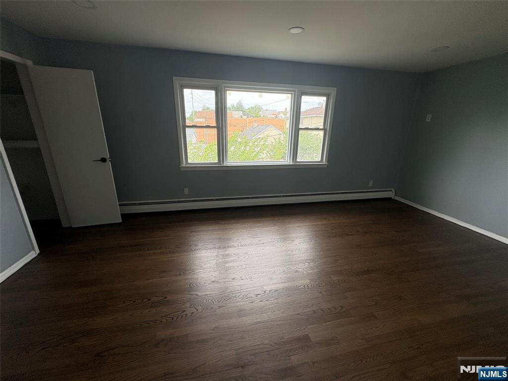 10 Strong Street, Unit 2 Wallington, NJ 07057 - Photo 6 of 12 an empty room with wooden floor and windows