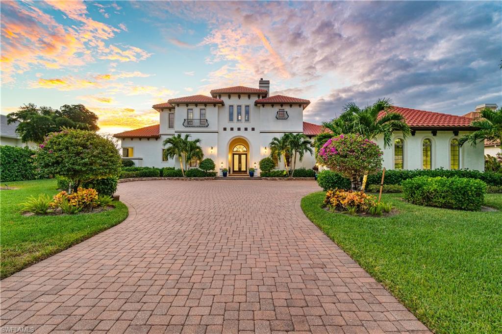 208 Audubon Boulevard Naples, FL 34110 - Photo 1 of 45 a front view of a multi story residential apartment building with a yard