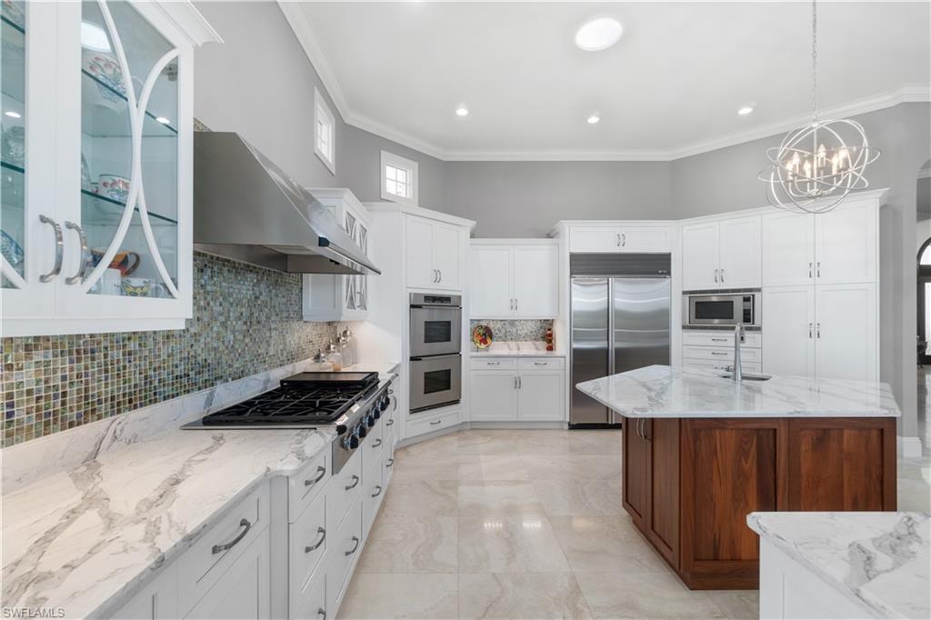 208 Audubon Boulevard Naples, FL 34110 - Photo 19 of 45 a kitchen with granite countertop a stove a sink and a refrigerator