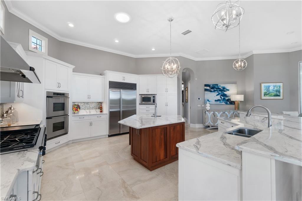 208 Audubon Boulevard Naples, FL 34110 - Photo 20 of 45 a kitchen that has a lot of cabinets and refrigerator in it