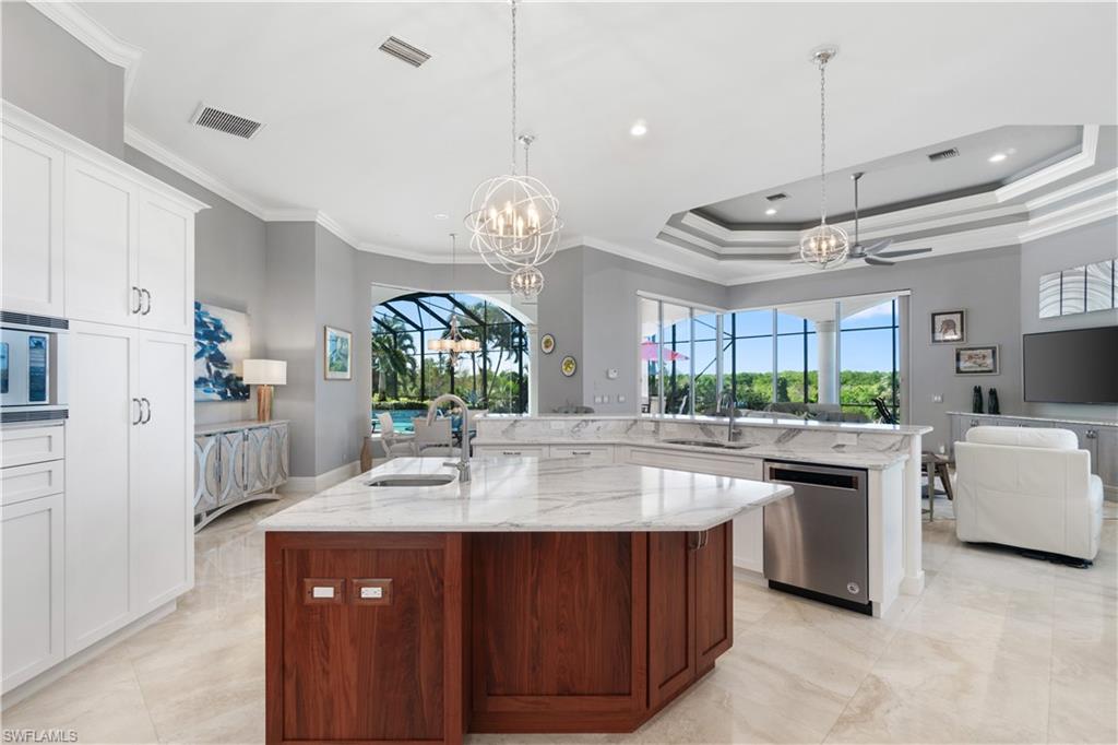 208 Audubon Boulevard Naples, FL 34110 - Photo 21 of 45 a large kitchen with kitchen island a stove a sink a center island and windows