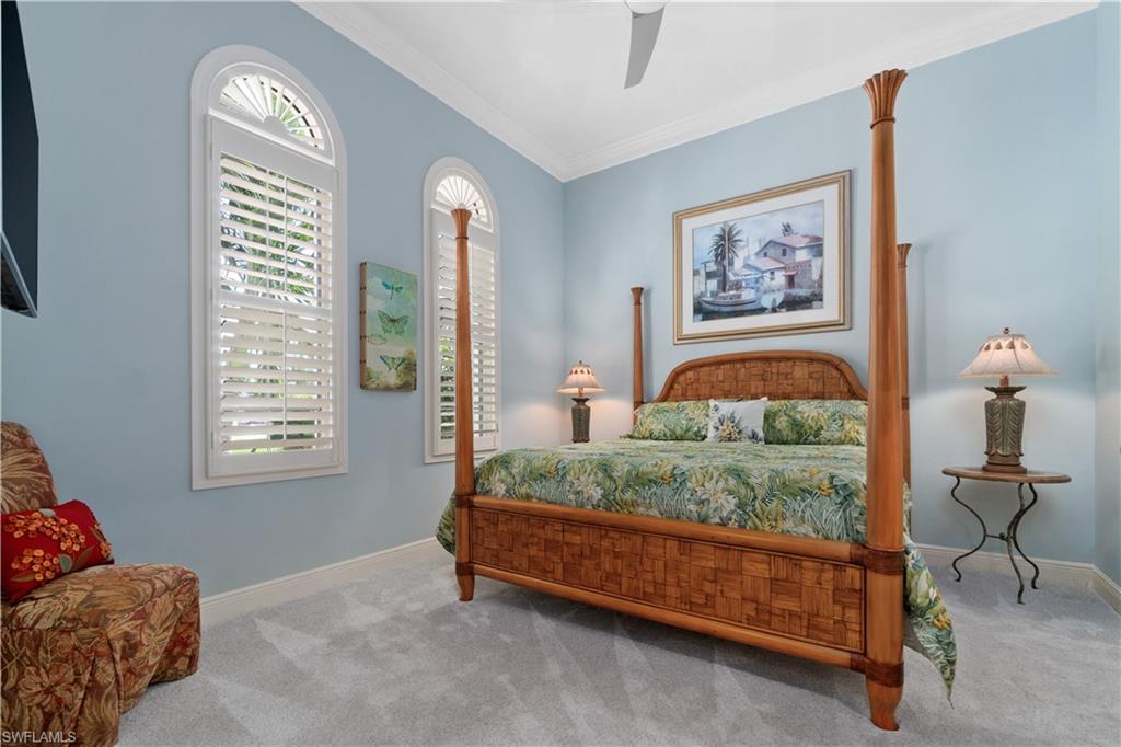 208 Audubon Boulevard Naples, FL 34110 - Photo 31 of 45 a bedroom with a bed and a chandelier
