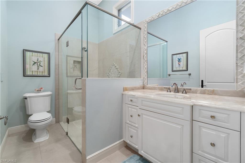 208 Audubon Boulevard Naples, FL 34110 - Photo 37 of 45 a bathroom with a granite countertop sink a toilet and a mirror