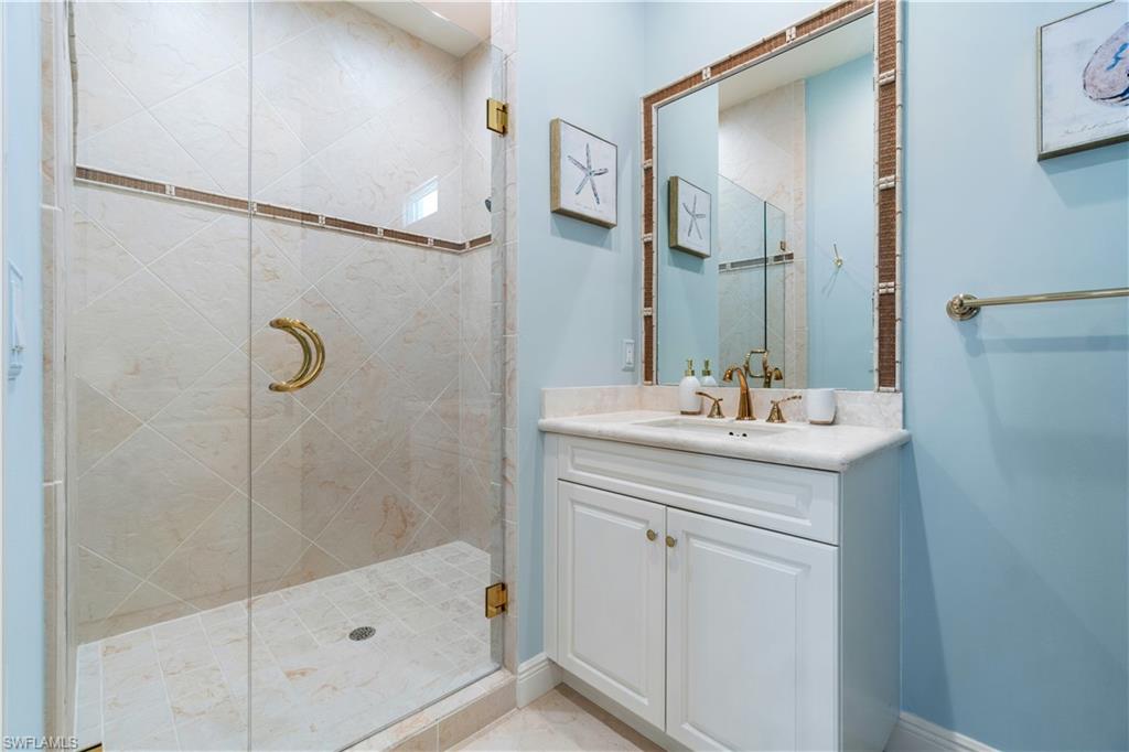 208 Audubon Boulevard Naples, FL 34110 - Photo 38 of 45 a bathroom with a shower sink and mirror