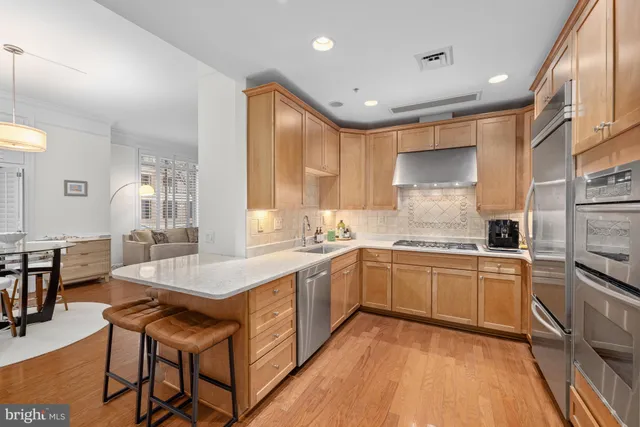 a spacious kitchen with stainless steel appliances granite countertop a sink and a refrigerator