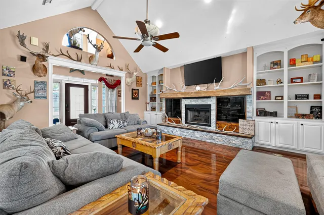 a living room with furniture a flat screen tv and a fireplace