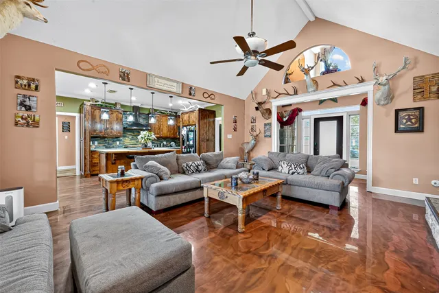 a living room with furniture a chandelier and a dining table