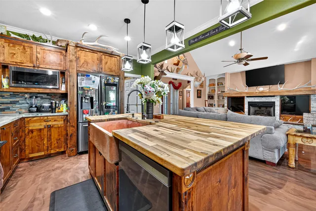a view of a kitchen with stainless steel appliances granite countertop a stove and a wooden floor