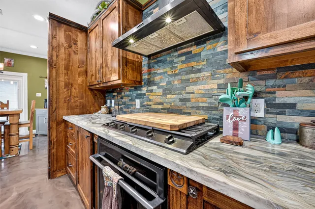 a kitchen with stainless steel appliances granite countertop a stove a sink and a refrigerator