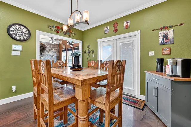 a kitchen with stainless steel appliances kitchen island granite countertop a stove a sink a dining table and chairs with wooden floor