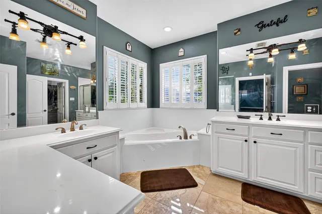 a bathroom with a granite countertop sink mirror and a bathtub