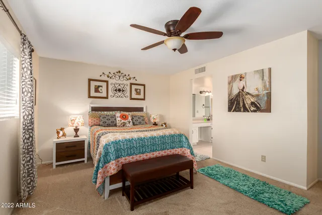 a bedroom with a bed and a painting on the wall