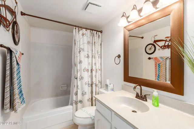 a bathroom with a granite countertop sink a toilet and shower