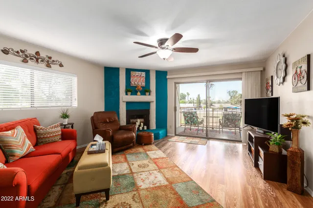 a living room with furniture a flat screen tv and a large window