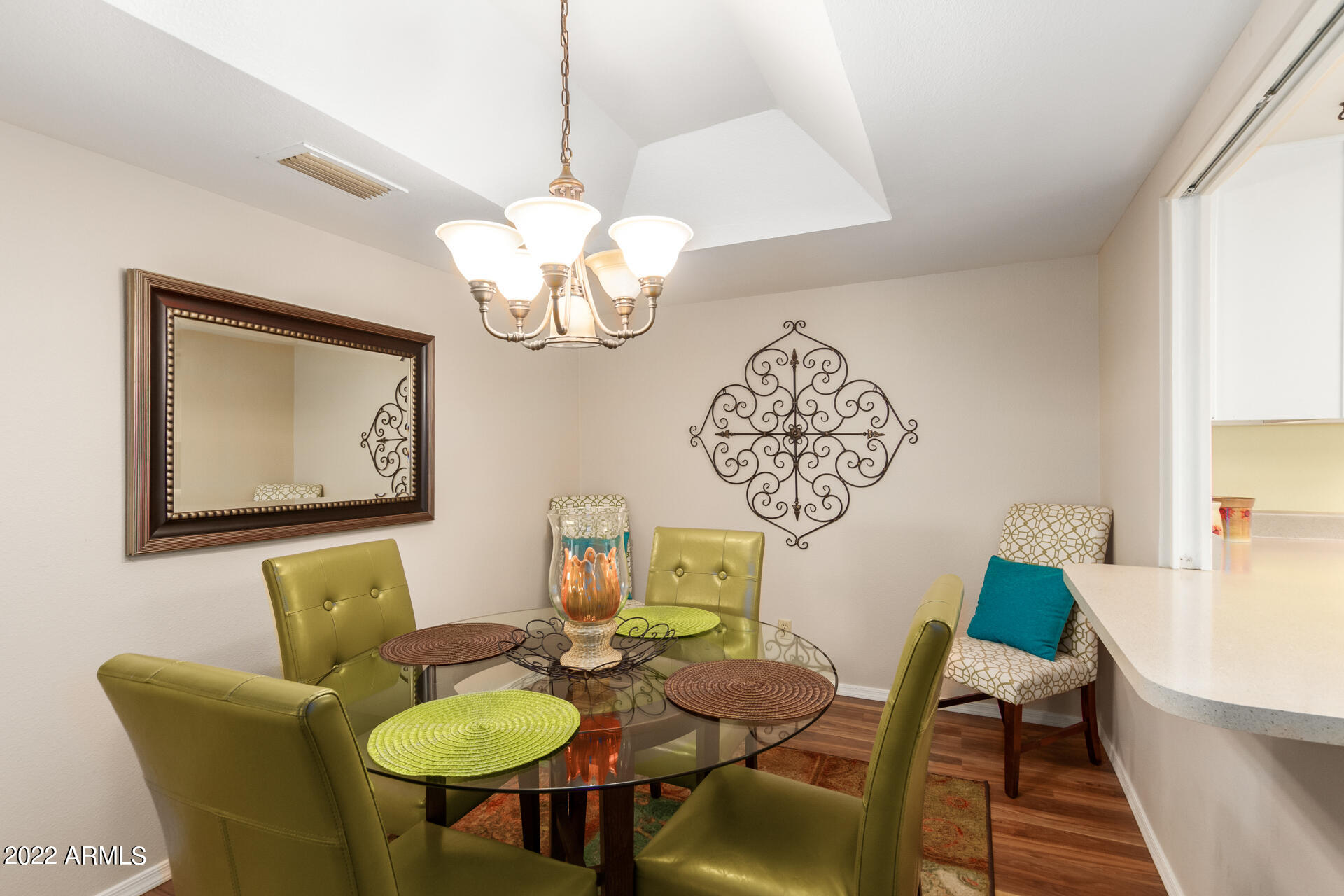 7005 East Broadway Road, Unit 28 Mesa, AZ 85208 - Photo 7 of 27 a view of a dining room with furniture a chandelier and wooden floor