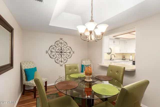 a view of a dining room with furniture a chandelier and wooden floor