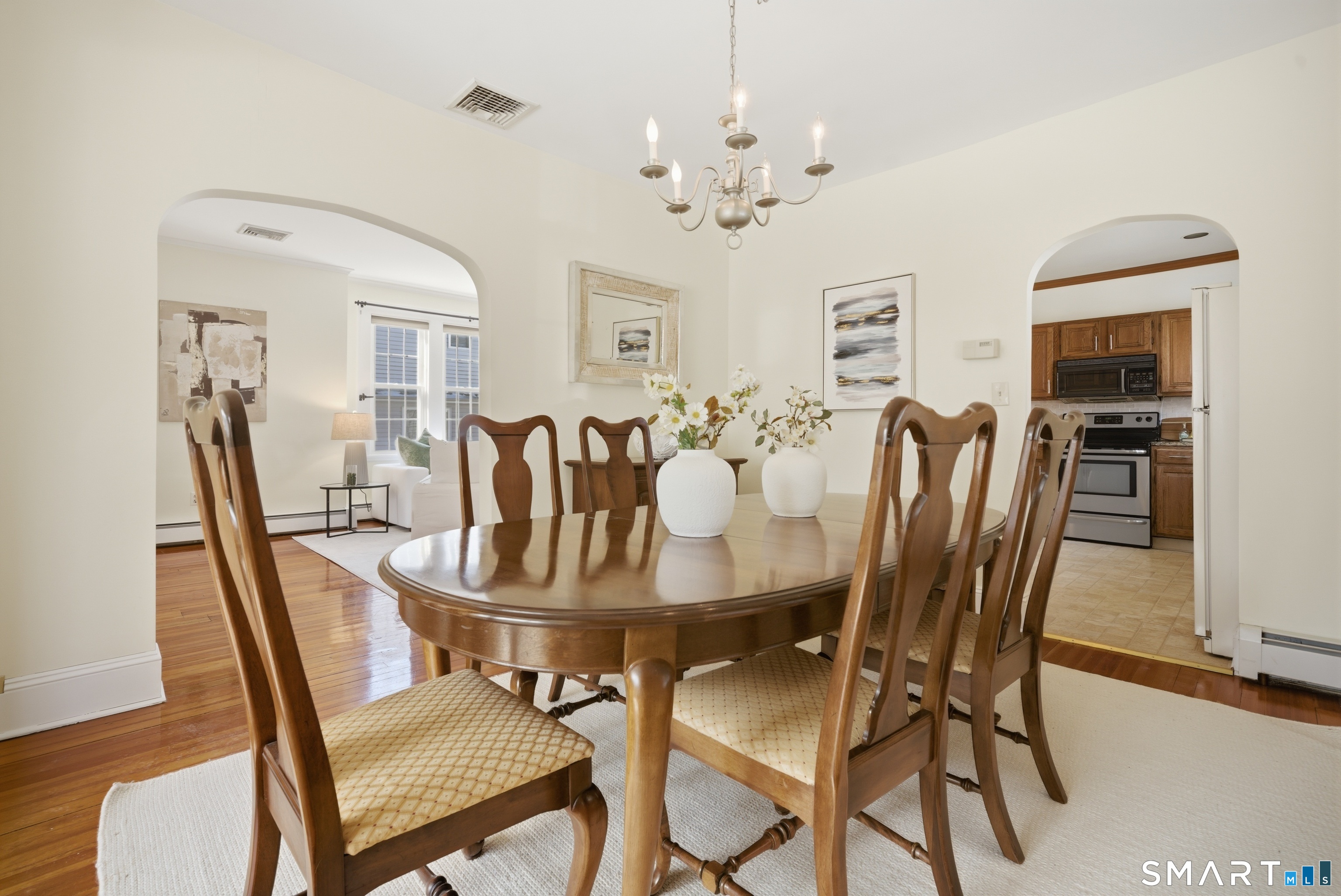 224 Homeland Street Fairfield, CT 06825 - Photo 10 of 37 a view of a dining room with furniture a chandelier and wooden floor