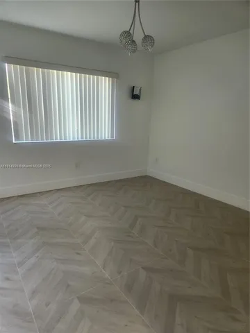 a view of wooden floor and window in a room