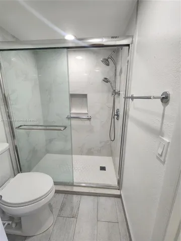 a bathroom with a toilet and a shower