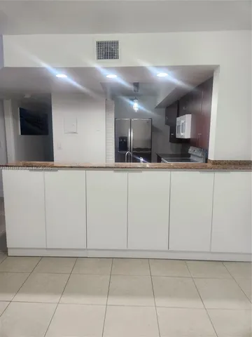 a kitchen with stainless steel appliances granite countertop a sink and white cabinets