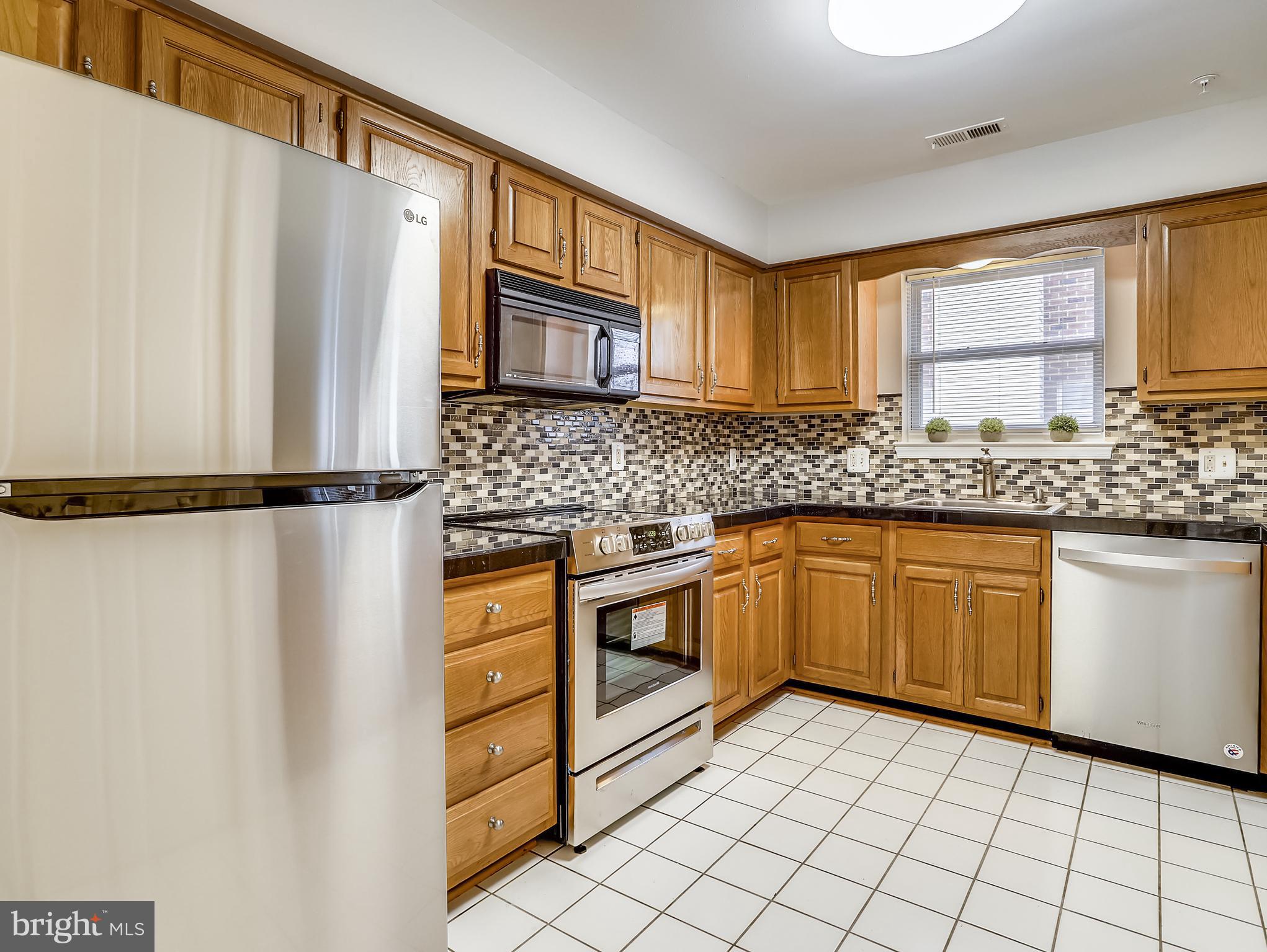936 Bay Ridge Avenue, Unit 106 Annapolis, MD 21403 - Photo 13 of 28 Oak cabinets and glass tile backsplash
