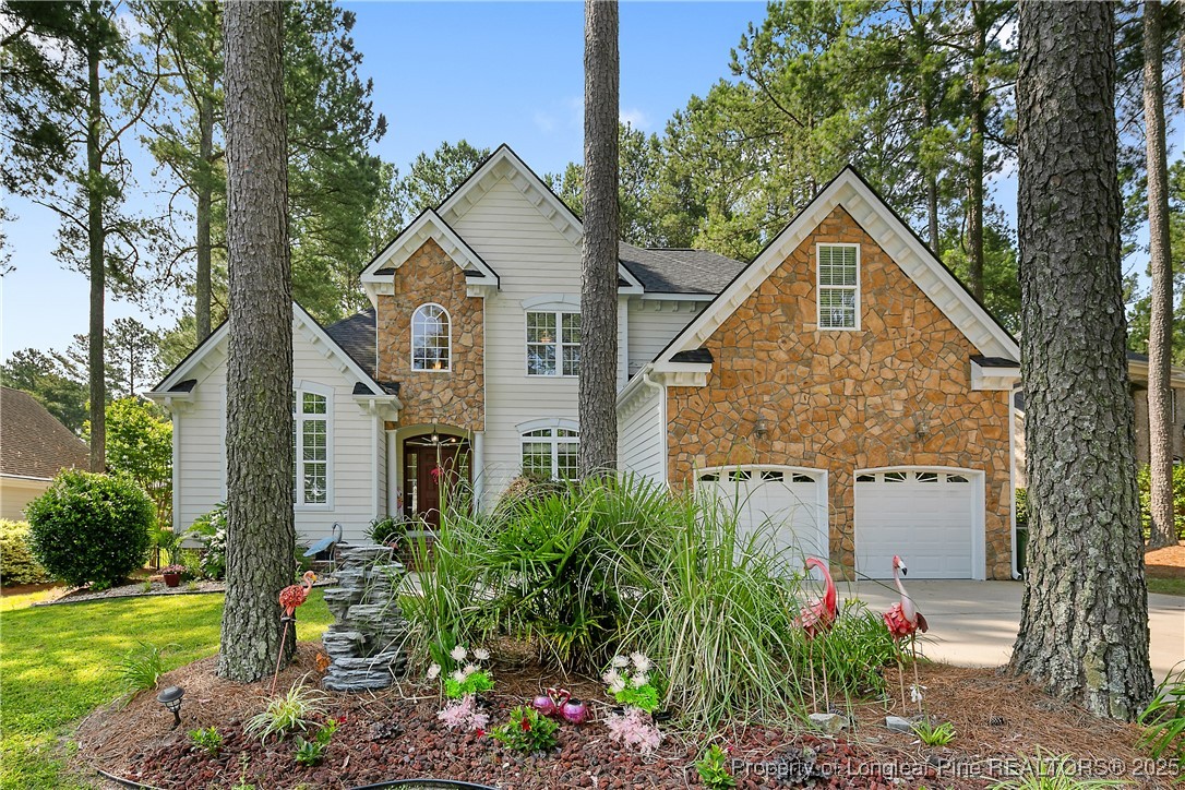 a view of a white house next to a yard with big trees