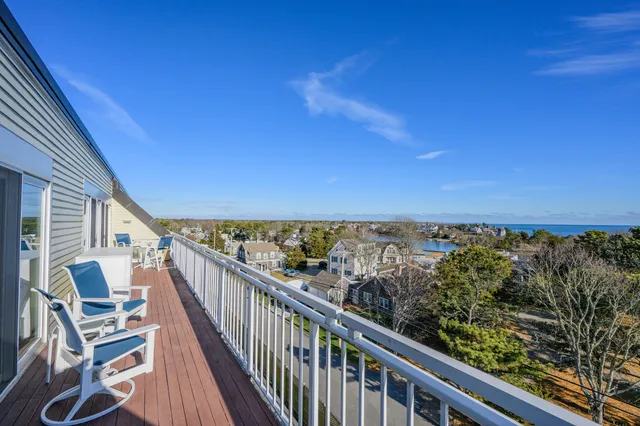 a view of a balcony with wooden floor and fence
